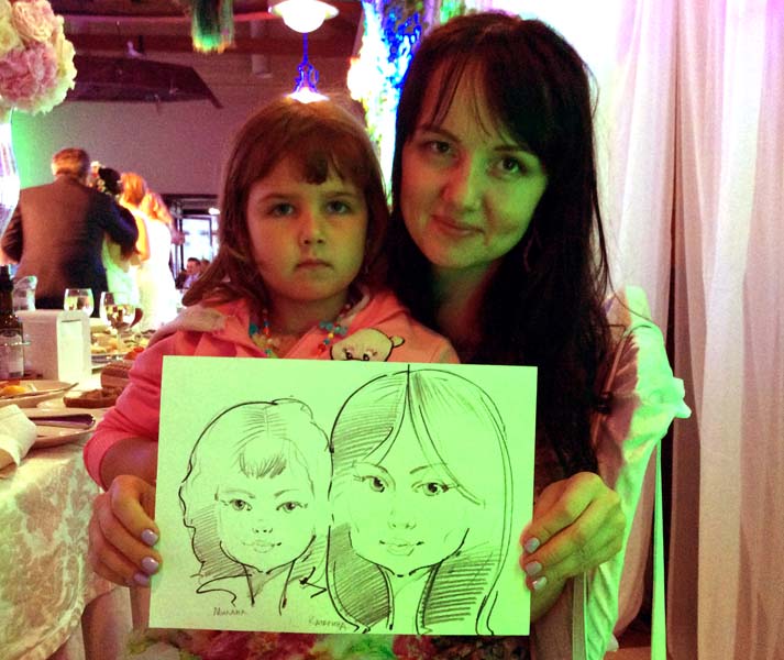 мама с дочкой показывают свой шарж на свадьбе