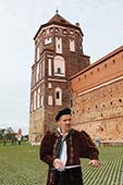 шаржист позирует на фоне Мирского замка шарж в Минске и в Калининграде