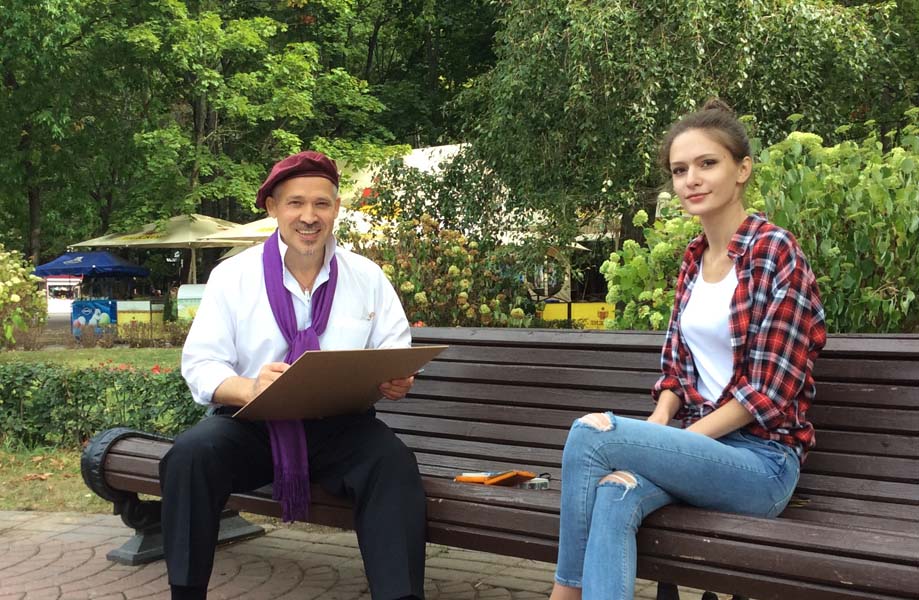 шаржист рисует шарж на выезде в парке Челюскинцев