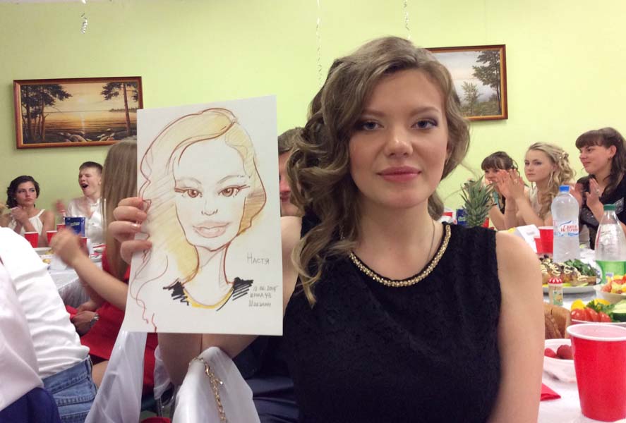 Шаржист рисует на празднике в школе